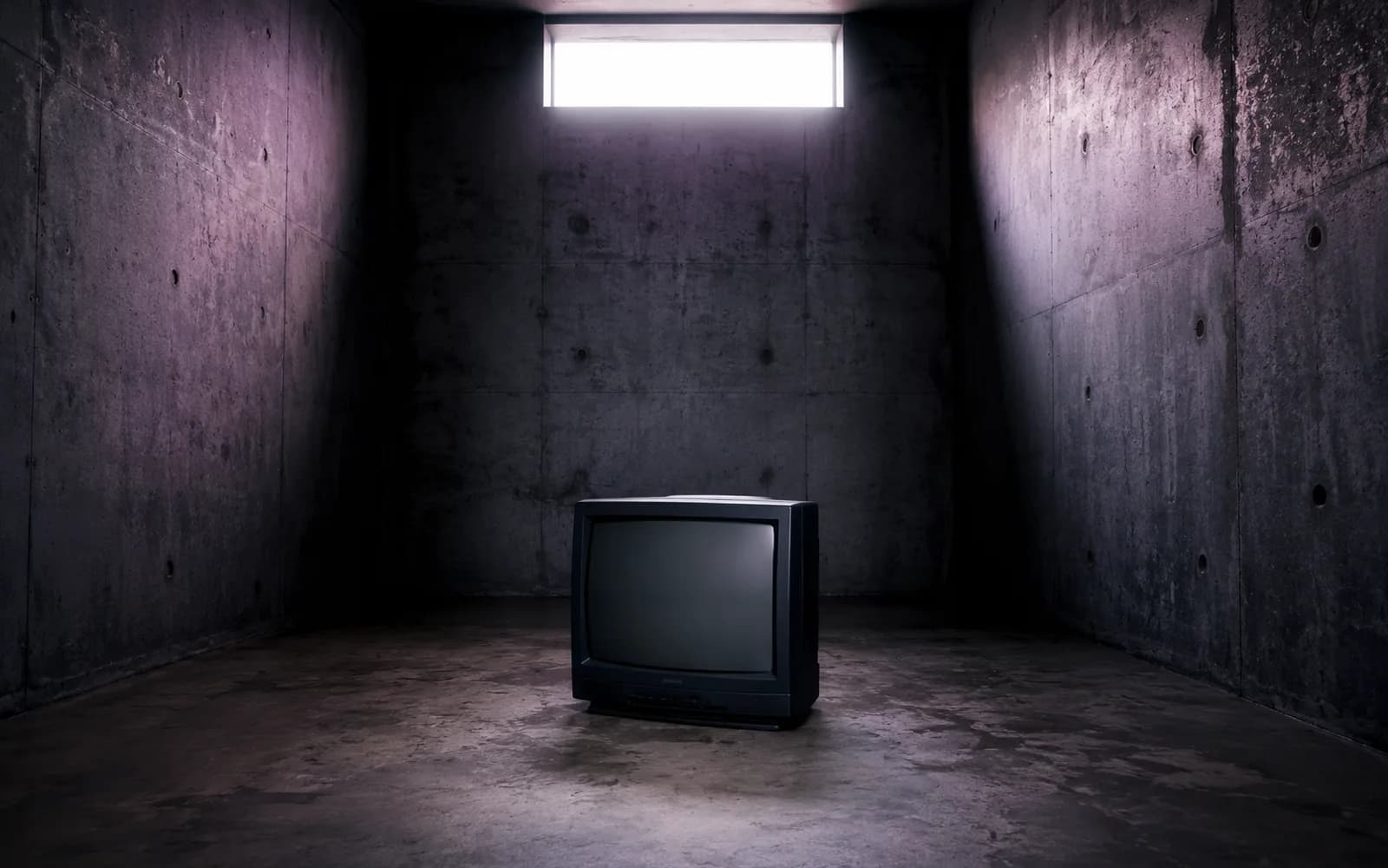 Stará televize v tlumeně osvětleném betonovém prostoru, ilustrační obrázek k článku